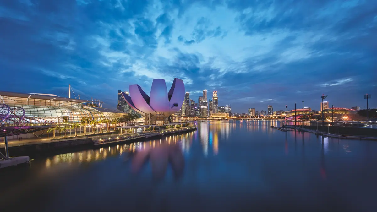 ArtScience Museum — The ArtScience Museum lit pink at dusk, reflected in the still water of Marina Bay