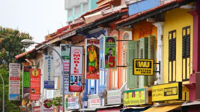 Little India — Brightly painted shophouses covered in shop signs on a street in Singapore's Little India