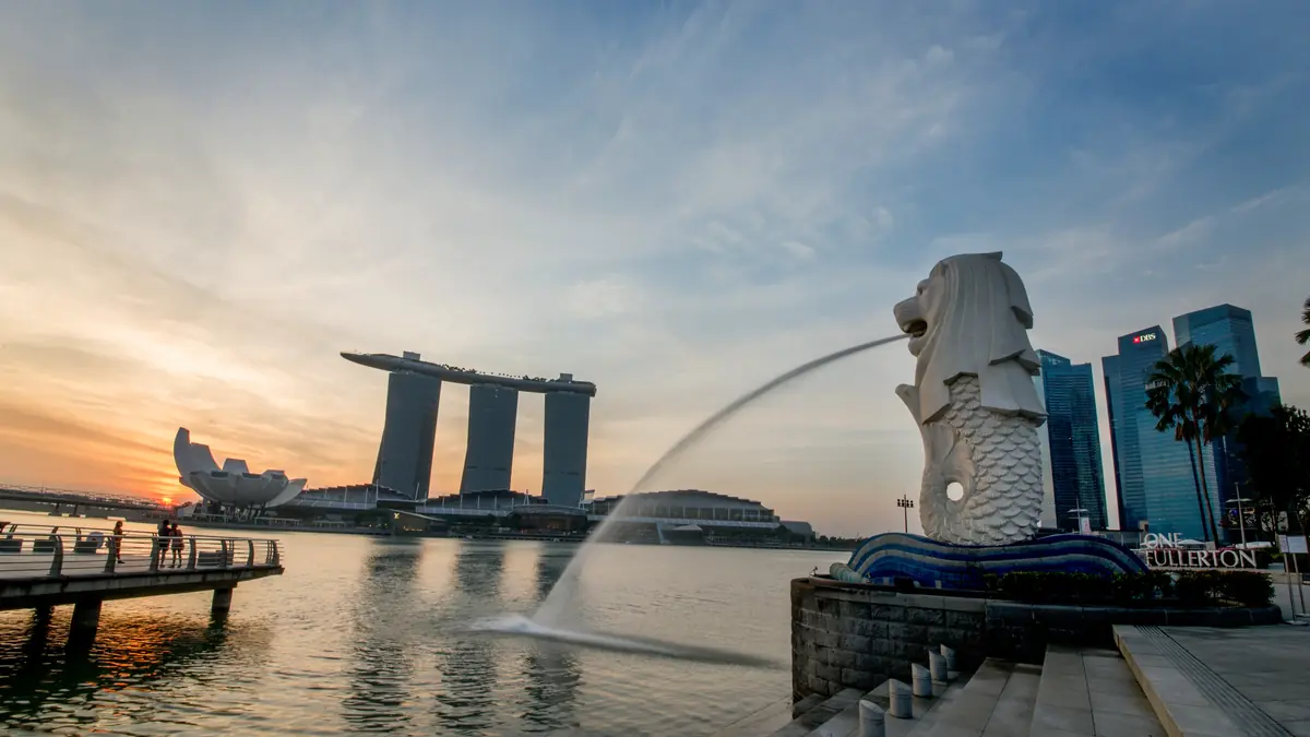 Merlion Park — The Merlion spouting water at sunrise with Marina Bay Sands and the ArtScience Museum across the bay