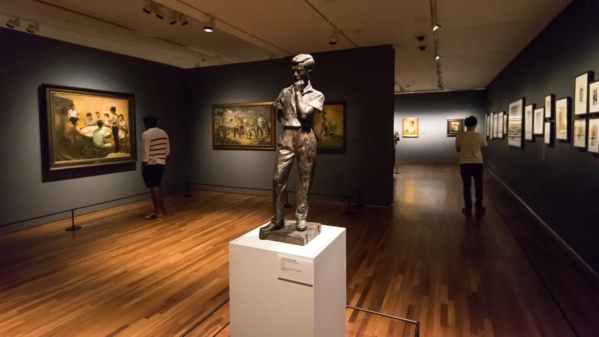 National Gallery Singapore — A bronze figure sculpture on a plinth in a painting gallery at National Gallery Singapore