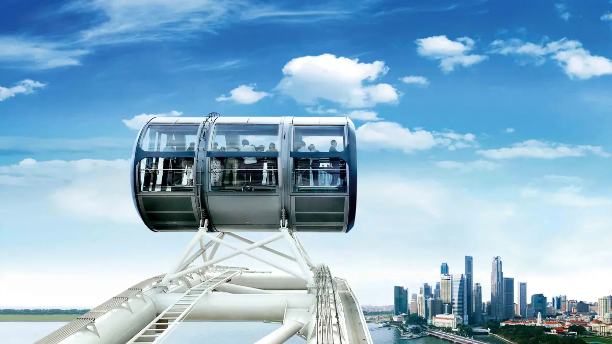 Singapore Flyer — Singapore Flyer capsules against a bright blue sky with passengers looking out