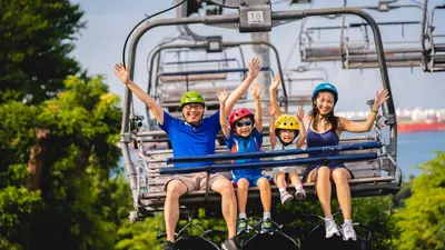 Skyline Luge Singapore — A family riding the Skyline Luge go-carts down the winding track on Sentosa, Singapore